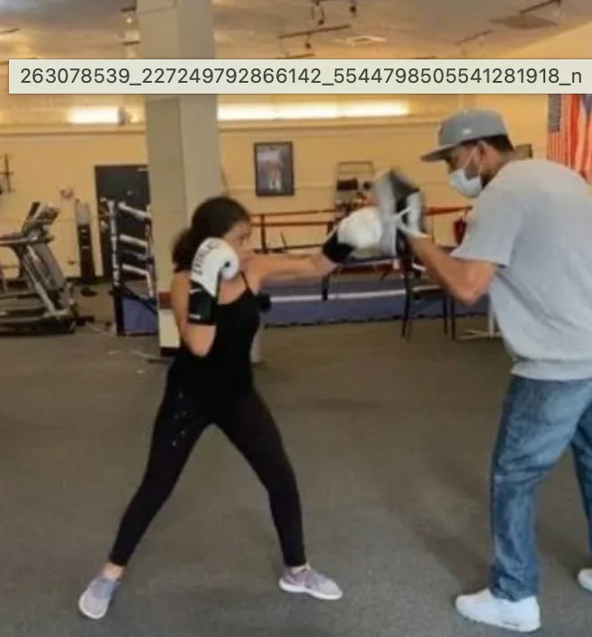 Coach working pads with athlete at Romero's Boxing School