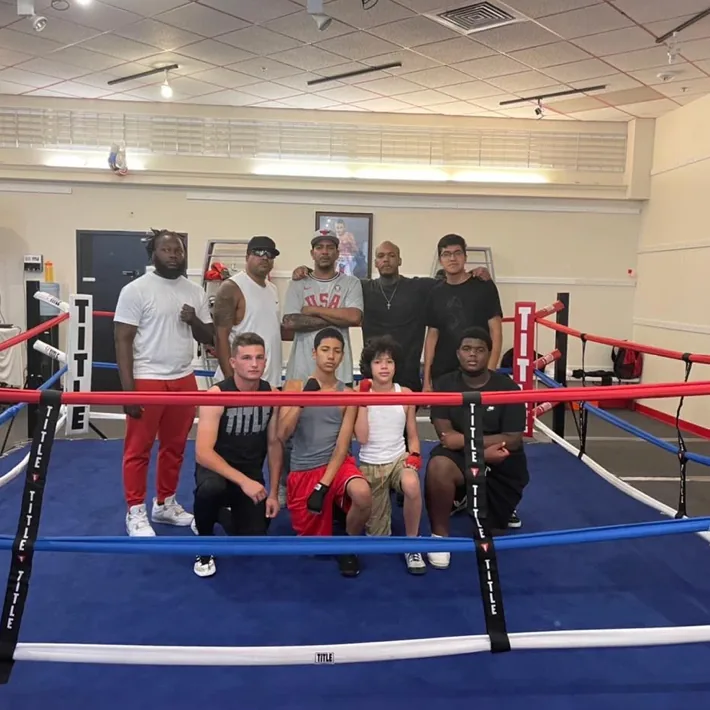 Coaches and members in the ring at Romero's Boxing School