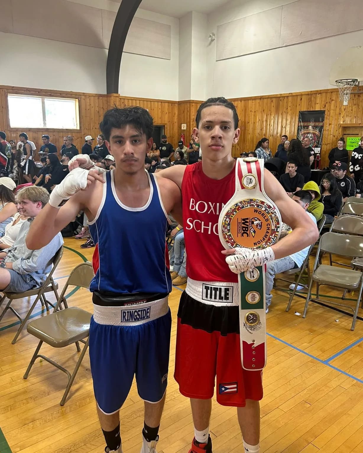 Romero's Boxing School athletes at a competition, holding a WBC championship belt