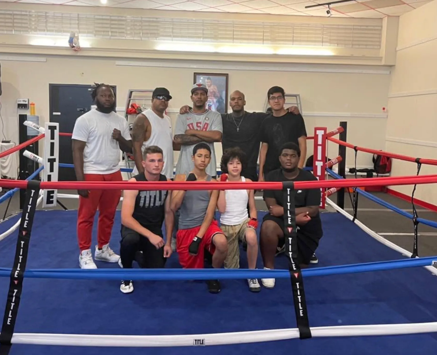 Coaches and athletes posing together inside the Romero's Boxing School ring