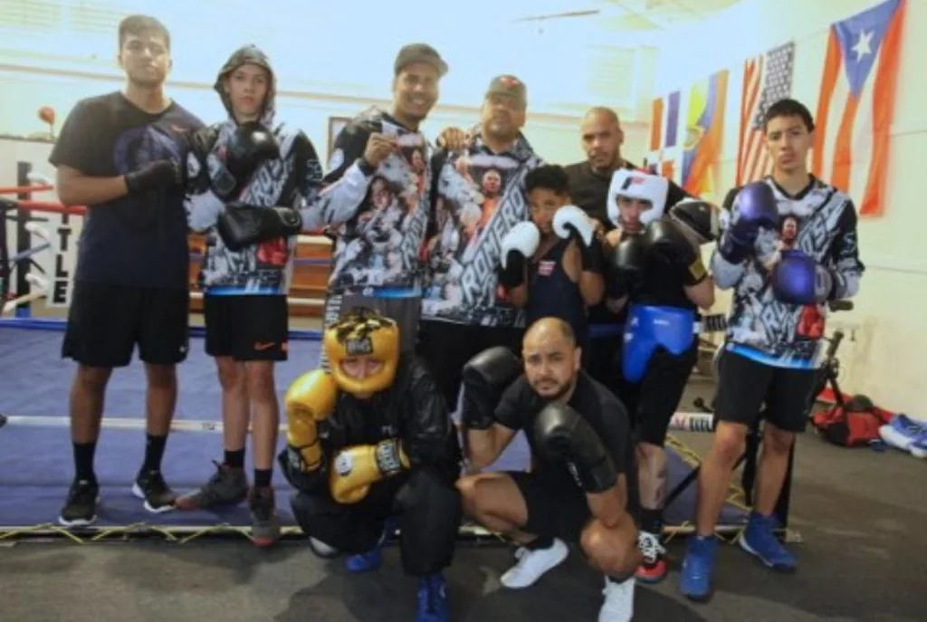 Romero's Boxing School team posing together in the ring wearing Romero hoodies