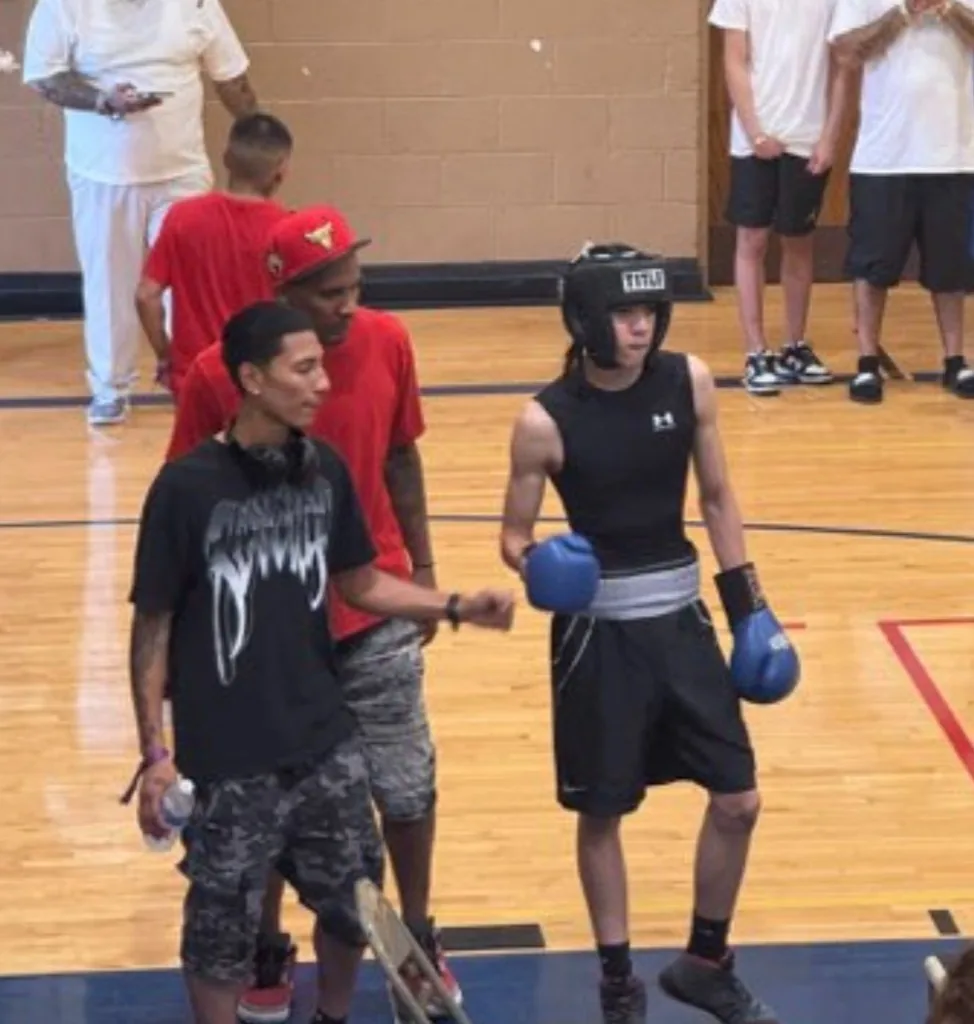 Young boxer with coaches at a competition event